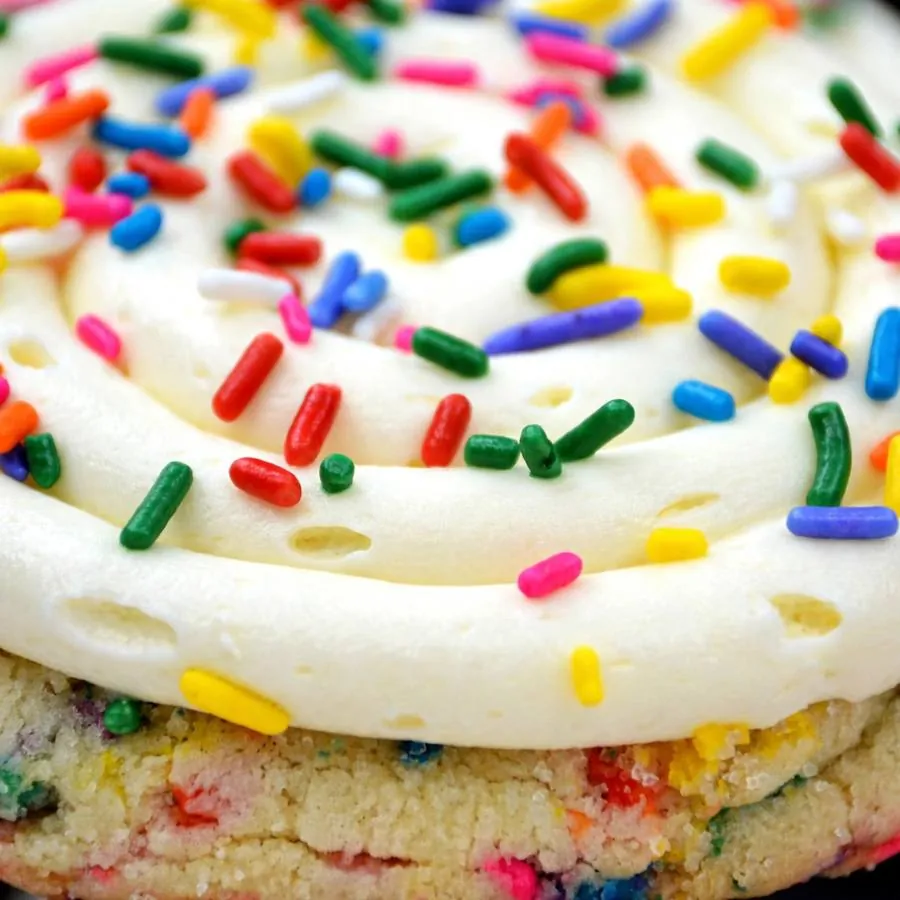 Vanilla frosting and rainbow sprinkles on a celebration cake cookie Vanilla frosting and rainbow sprinkles on a celebration cake cookie
